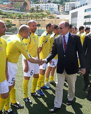 Prince Albert II of Monaco shaking hands with football players