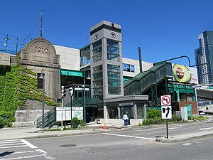 An elevated light rail station in an urban area seen from below