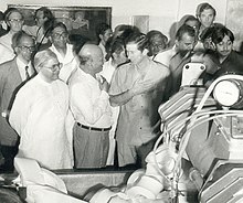 Black and white photograph of Charles in Gujarat with a crowd of people, 1980