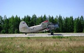 El pequeño biplano Antonov An-2 a punto de despegar, con rueda de cola en el aire.