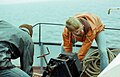 Marine ecologists aboard a research ship and next to a dredge winch