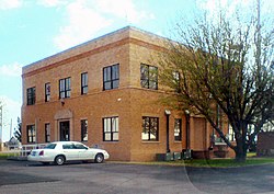 A two-story courthouse seen from its parking lot