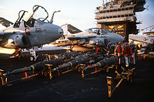 Laser-guided bombs line the flight deck of John F. Kennedy in preparation for air strikes against Iraq during Operation Desert Storm on 23 January 1991. The A-6E Intruder aircraft in the background is armed with laser-guided bombs. DN-ST-91-04361.jpg