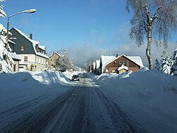 Hlavní silnice s bývalou nádražní budovou vpravo