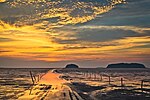 Sunset over tidal flats with some islands in the background