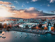 Man sieht das Kongresshaus Zürich aus der Vogelperspektive bei Sonnenuntergang. Im Vordergrund ist der Zürichsee.