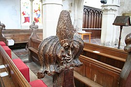 The carved poppyhead pew finials with grotesque faces