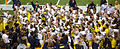 Michigan players celebrate, hoisting the Little Brown Jug in victory