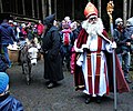 Samichlaus, der Schmutzli en hun ezel worden door kinderen opgehaald bij een boshut en naar het dorp begeleid tijdens het Klausjagen in Küssnacht (Zwitserland)