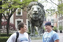 Football players chat before The Scholar's Lion Scholar's Lion.jpg