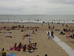 Vue en couleur d'une plage et de baigneurs.