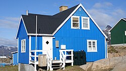 Forskellige typer af bebyggelse i Sisimiut, et præfabrikeret enfamilieshus (venstre) og lejlighedsblokke fra 1960'erne (højre).