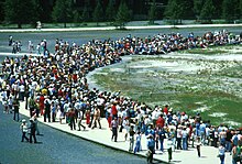 Photographie d'une foule à proximité du cratère d'un geyser.