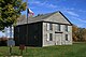 Exterior view of the Old Hay Bay Church with Canada flag and plaque out front