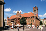 Red brick gothic town hall, tourists around