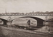 Photographie d'un pont en pierre dont les piles sont décorées par d'imposantes statues de soldats