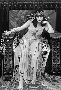 Theda Bara poses in a still image from Cleopatra. Exotic sets and costumes, depicting a fantasy version of ancient Egypt, were a good fit for Theda Bara's popular "vamp" image. Theda-bara-cleopatra.jpg