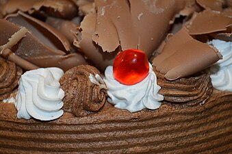 Chocolate truffle cake with icing and whipped cream