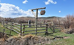 Image of a monument surrounded by fences and brush.