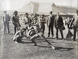 Photographie d'un homme en pagne lançant une sagaie