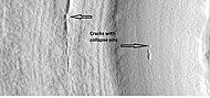 Close-up that shows cracks containing pits on the floor of a crater containing concentric crater fill, as seen by HiRISE under HiWish program. Location is Casius quadrangle.