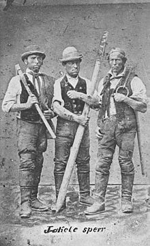 River drivers in Germany with a crude pike pole the Germans call a rafters' hook (Flosserhaken, as in rafting logs), probably one or two pickaroons and a ring dog for rolling logs over. Flosserei Drei Flosser.jpg