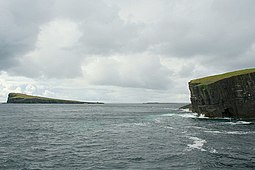 Southwards from the eastern edge of the Horse of Copinsay. Copinsay lighthouse is on the high ground in the distance.