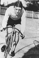 Photographie en noir et blanc d'un homme chevauchant une bicyclette.