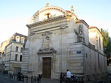 La paroisse orthodoxe Saint-Joseph. Un bâtiment en pierre entouré par des bâtiments d'habitation.