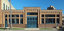 One-story brick building with decorative cornice and slightly raised central entry