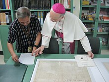 Angelo Vincenzo Zani, Secretary of the Congregation for Catholic Education of the Holy See (Vatican), examining historic documents related to the university's establishment during his visit to the Archives, on 21 January 2015. UST Archives.JPG