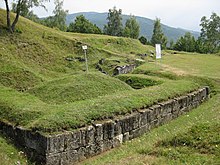 Murs en pierre, site en ruine recouvert d'herbes.