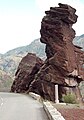 Busto de mulher com chapéu, cabeça virada, xisto dominando a estrada (em desfiladeiros de Daluis, França).