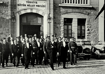 Türkiye Cumhuriyeti'nin ilk cumhurbaşkanı Mustafa Kemal Atatürk, yanında İsmet İnönü, Fevzi Çakmak ve kadrosunun diğer üyeleriyle birlikte TBMM'den çıkıyor. (29 Ekim 1930). (Üreten: Bilinmiyor)