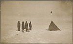 De gauche à droite, Roald Amundsen, Helmer Hanssen, Sverre Hassel et Oscar Wisting à Polheim, le camp de base installé au pôle Sud le 16 décembre 1911. Le drapeau est celui de la Norvège. Photographie d'Olav Bjaaland.