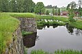 Ruinens nordlige del med lakseopdrættet i baggrunden.