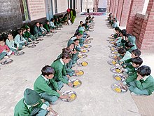 School students taking Mid day meal in a school of Haryana province of India Mid day meal.jpg