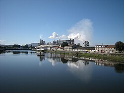 O rio Ulla à sua passagem por Pontecesures; ao fundo: a fábrica de leite condesado da Nestlé