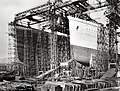 Titanic's hull (left) during one of the early stages of her construction. Next to her, is the Olympic's hull (right), completed and ready to be launched, October 1910