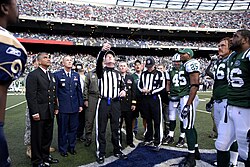 Players and officials looking up at a tossed coin