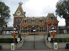 A flight of stairs lead to an old-fashioned railroad station building.