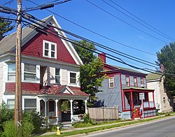 A red and white house next to a smaller one in blue with red trim