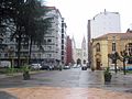 La Ilesia de Santiagu (centru) y l'edificiu de la Sociedá La Montera (derecha) dende'l Parque Dorado