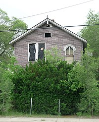 Front facade of the Philetus Norris house from across Mount Elliot. The first floor is hidden by vegetation. PhiletusNorrisFacade.jpg