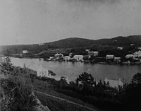 Khung cảnh năm 1904 nhìn qua Cảng Hamilton từ Pháo đài Hamilton với những ngọn đồi phủ tuyết tùng ở Giáo xứ Paget