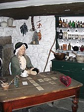 A model of a nineteenth-century cunning woman in her house, at the Museum of Witchcraft, Boscastle in England Cunning Woman.jpg