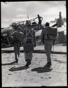 Members of a torpedo bomber crew prepare to leave from Bougainville air strip on a strike at Rabaul. In center is the pilot; to his left is the turret gunner; to right, radio-gunner. 127-N-77860.tif