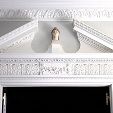 Plaster bust in split pediment.