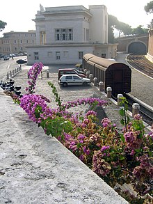 תחנת הרכבת של הוותיקן במבט מכיוון צפון. הקרונות הנראים בתמונה משמשים למטען. מצד ימין למעלה נראה השער בחומה הדרומית של קריית הוותיקן, כשדלתותיו מוגפות