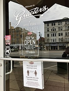 Signs read "We're open, carryout & order pickup only at this time. Get it delivered." and "Please keep social distancing in mind. Keep six feet apart from one another. Please take your order to go once received. Thank you for helping us comply with govermental health recommedations."